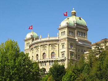 wikimedia: (Das Bundeshaus in der Bundesstadt Bern, Schweiz. Die Stadt ist zwar Sitz der Bundesversammlung, de jure hat die Schweiz keine Hauptstadt (siehe Hauptstadtfrage der Schweiz)™, (Bundeshaus-waehrend-Session.jpg)™